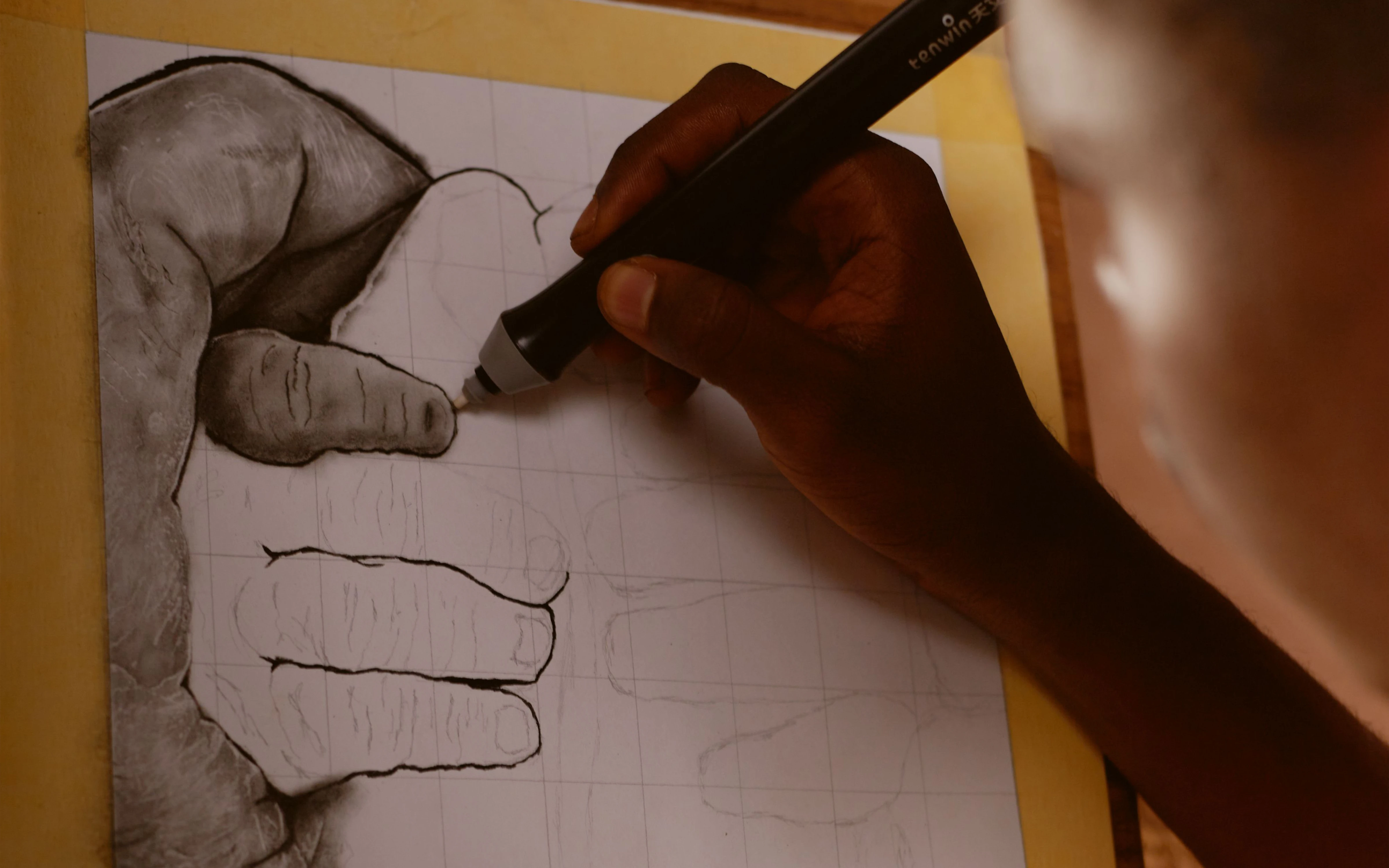 Artist sketching with charcoal pencil using the grid method