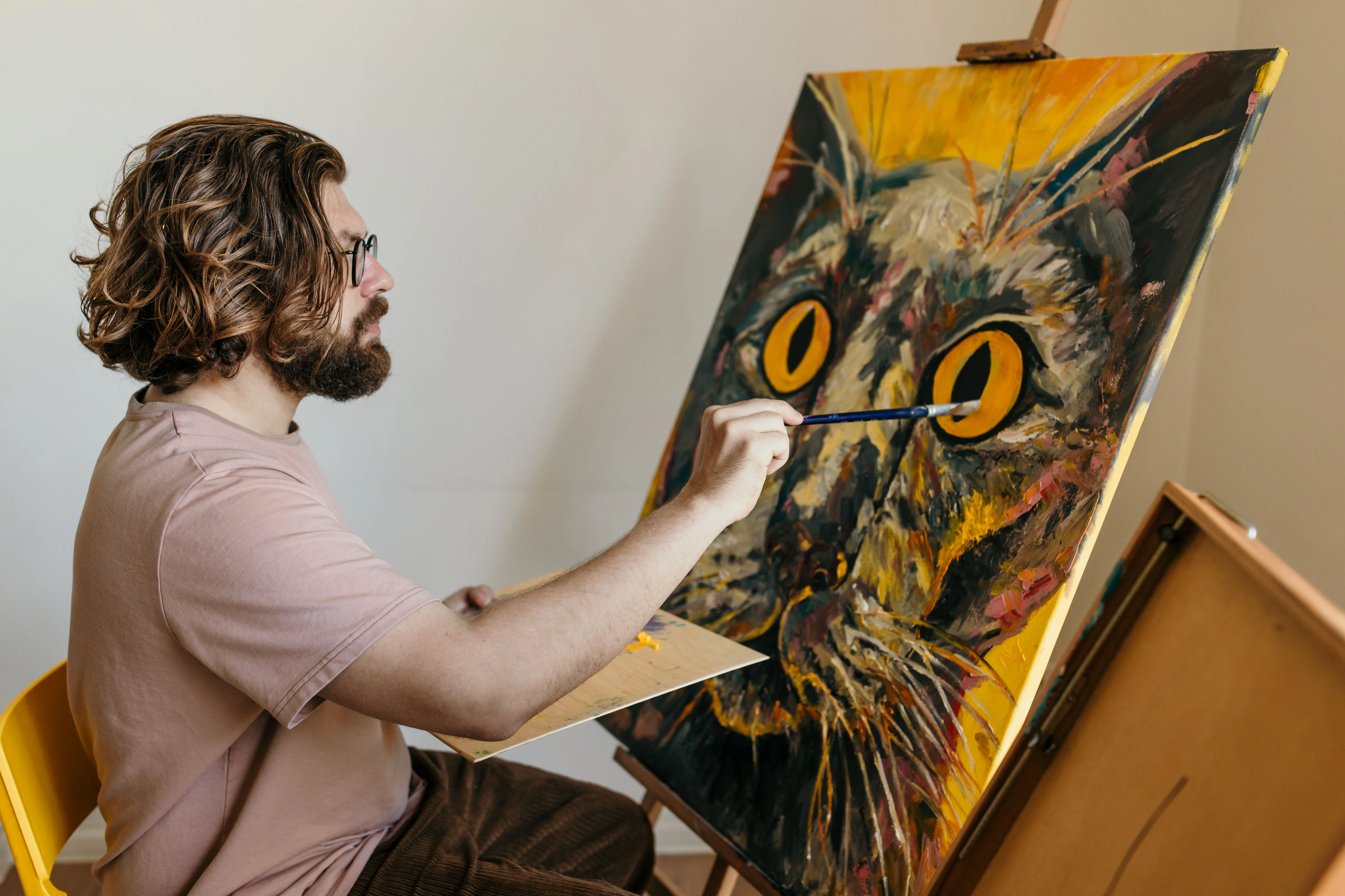 An artist working carefully at an easel