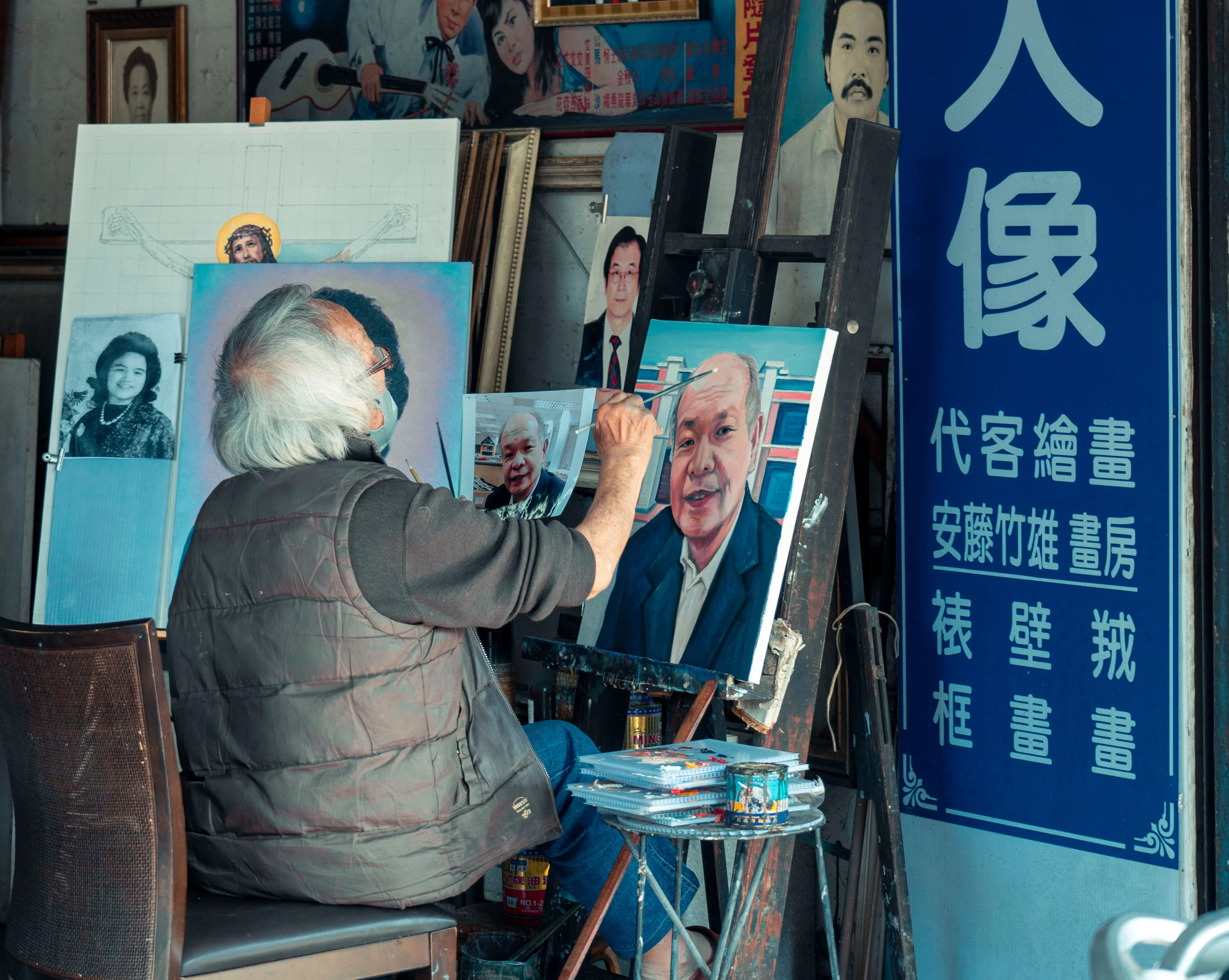 Elderly man doing portrait painting at an easel